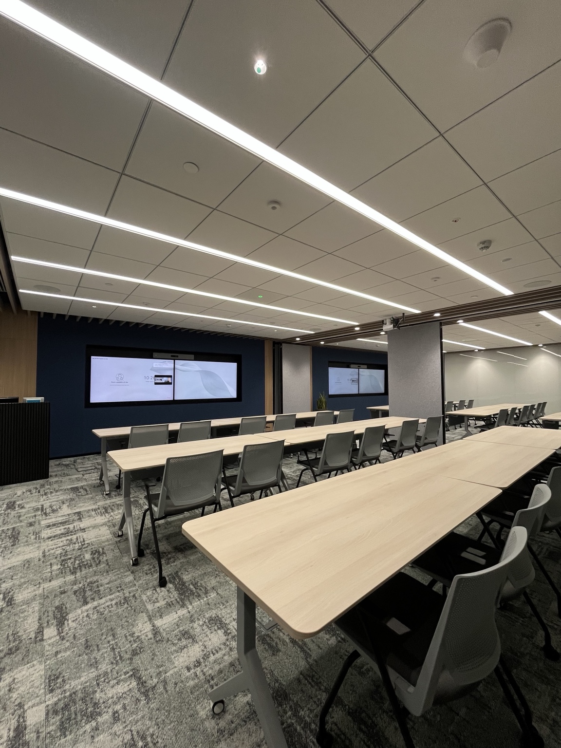 A divisible training environment with multiple displays and flexible seating arrangements.